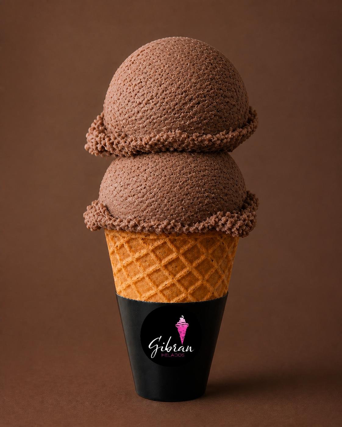 Cono de helado Dxuladi, cacao de Oaxaca de Helados Gibran, CDMX. Sabor exclusivo de la membresía Helados Gibran. Sabor prehispánico. Desde $30 MXN la bola (2 bolas $50 MXN); litro $250 MXN (0.5 L $150, 4 L $950). Versión sin azúcar bajo pedido, endulzada con miel o fruta.